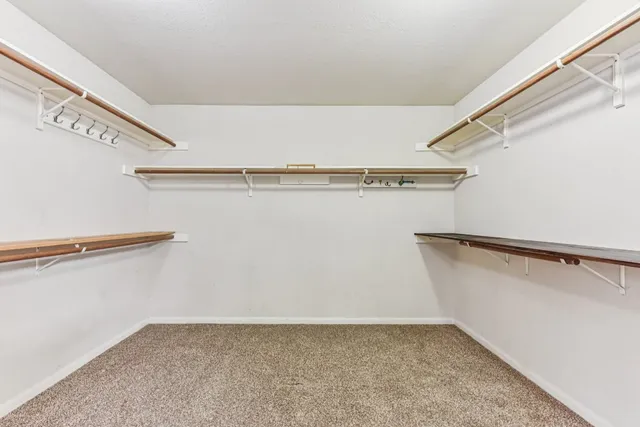 an empty room with closet and a chandelier fan
