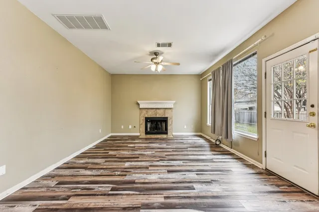 a view of an empty room with a fireplace and a window