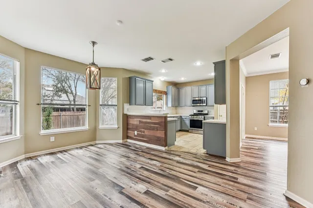 a view of kitchen with sink refrigerator and cabinets