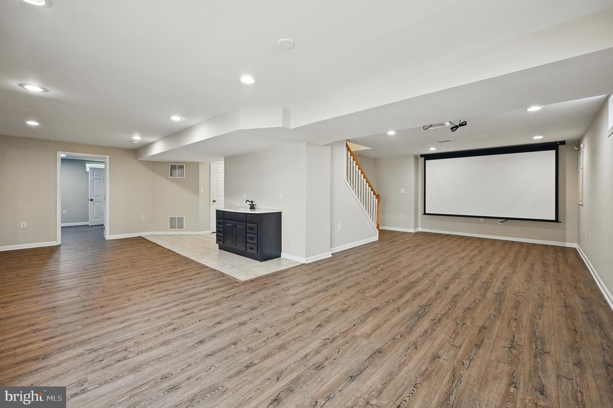 10861 Hunter Gate Way Reston, VA 20194 - Photo 50 of 79 a view of an empty room with wooden floor and kitchen space