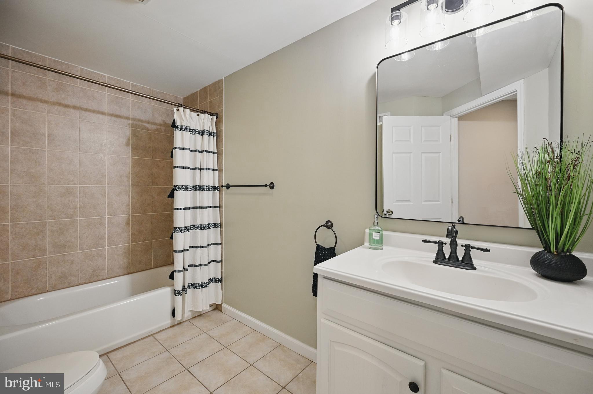 10861 Hunter Gate Way Reston, VA 20194 - Photo 58 of 79 a bathroom with a sink a mirror a bathtub and shower