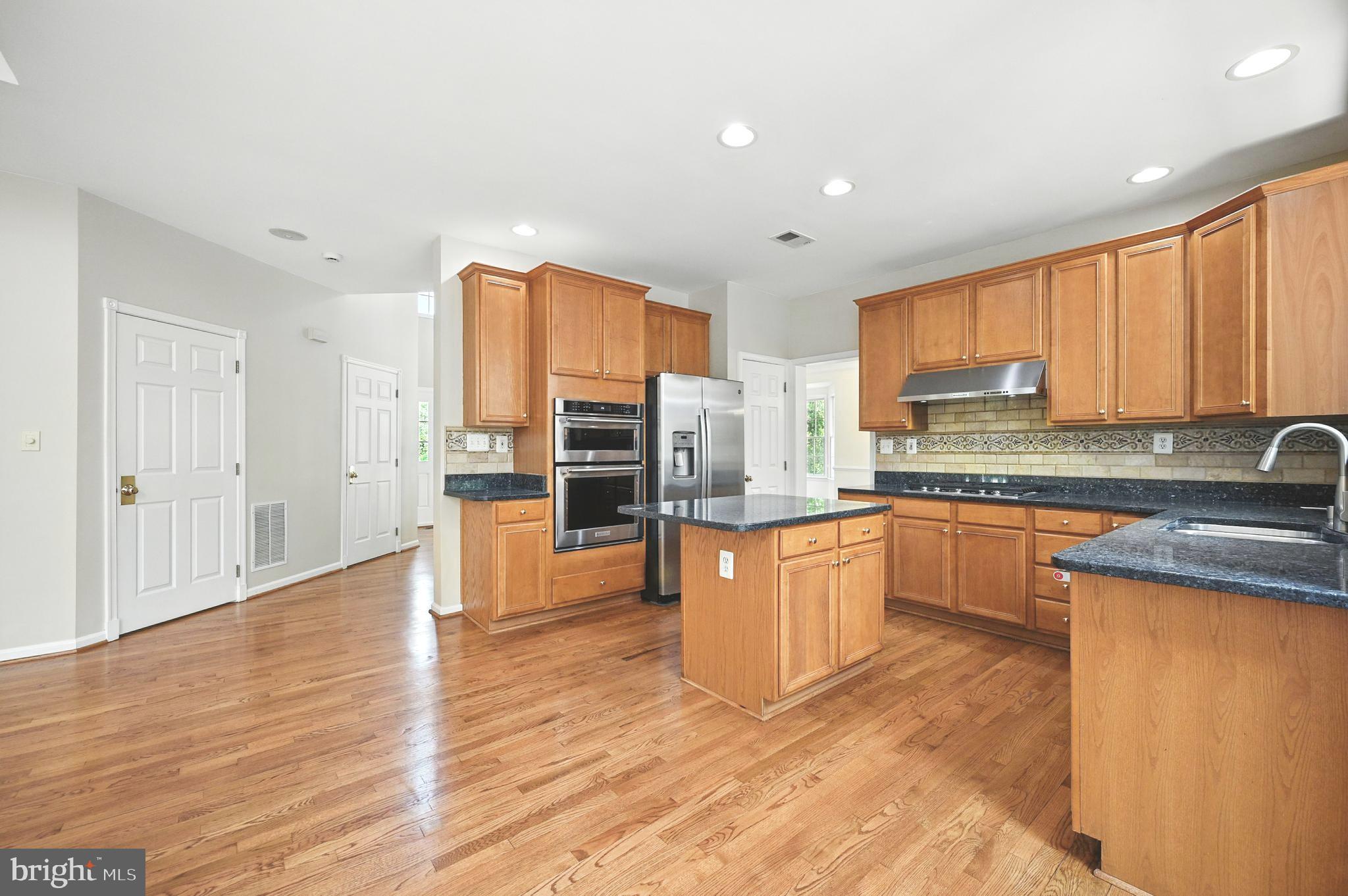 10861 Hunter Gate Way Reston, VA 20194 - Photo 8 of 79 a large kitchen with stainless steel appliances granite countertop a stove a sink dishwasher and a refrigerator with wooden floor