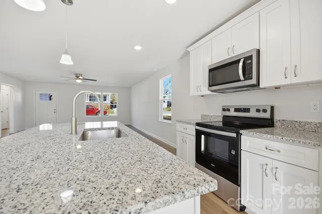 a kitchen with stainless steel appliances granite countertop a stove a microwave and a sink