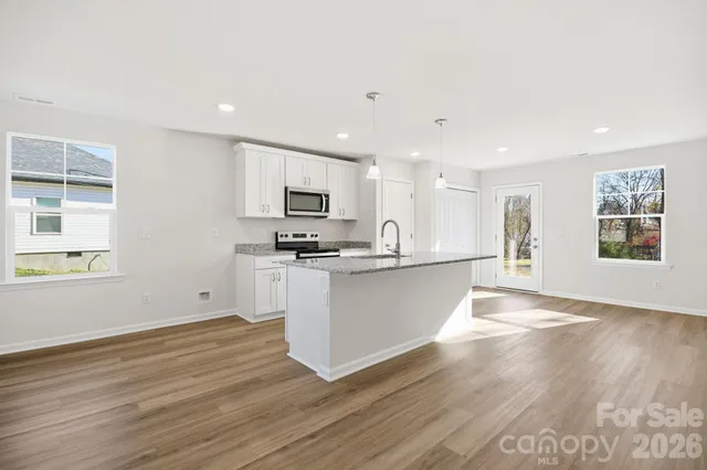 a view of kitchen with wooden floor and electronic appliances