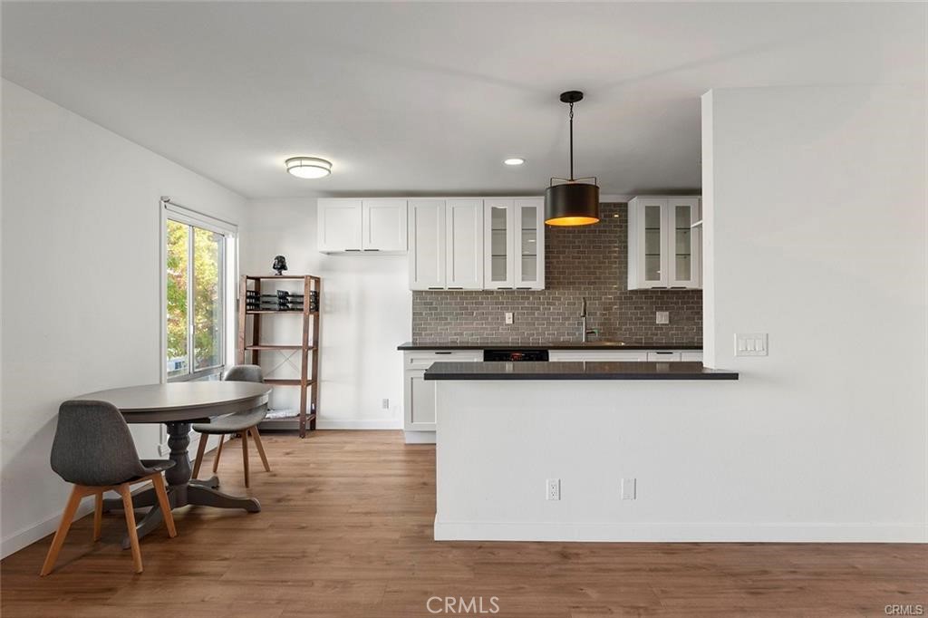 17034 Colima Road, Unit 126 Hacienda Heights, CA 91745 - Photo 6 of 24 a kitchen with stainless steel appliances granite countertop a stove top oven a sink a dining table and chairs with wooden floor