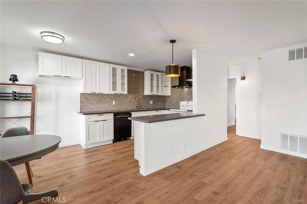 17034 Colima Road, Unit 126 Hacienda Heights, CA 91745 - Photo 7 of 24 a kitchen with granite countertop wooden floors and white cabinets
