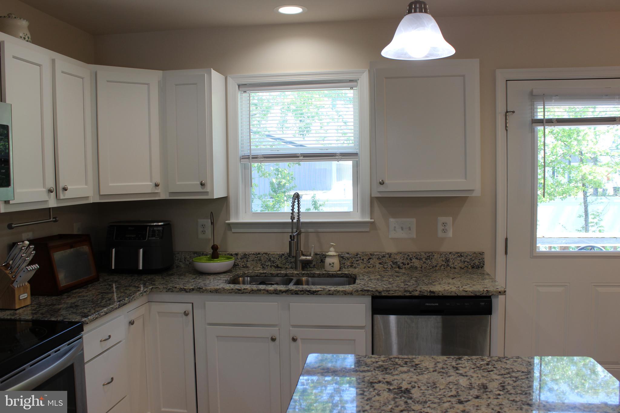 48 Rustic Lane Colonial Beach, VA 22443 - Photo 6 of 29 a kitchen with granite countertop white cabinets and window