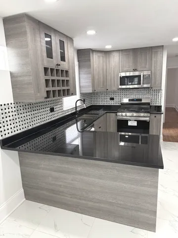 a kitchen with granite countertop a stove and cabinets
