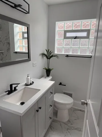 a bathroom with a toilet sink and mirror