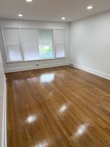 an empty room with wooden floor and windows in it