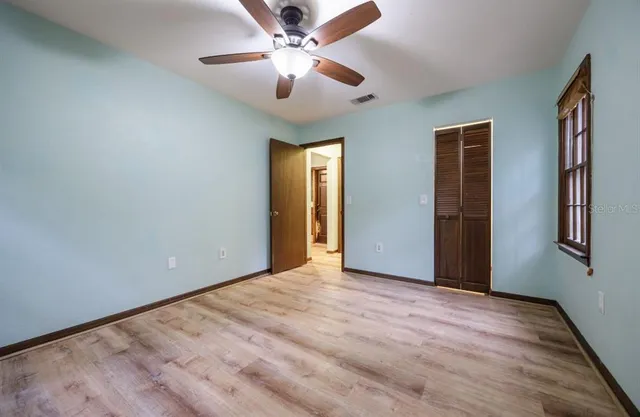 a view of an empty room with a chandelier fan
