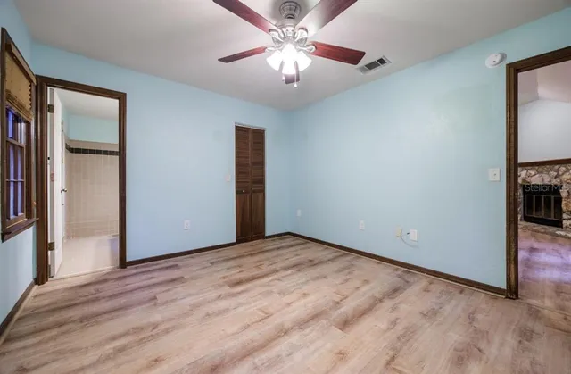 a view of a room with a ceiling fan and a window