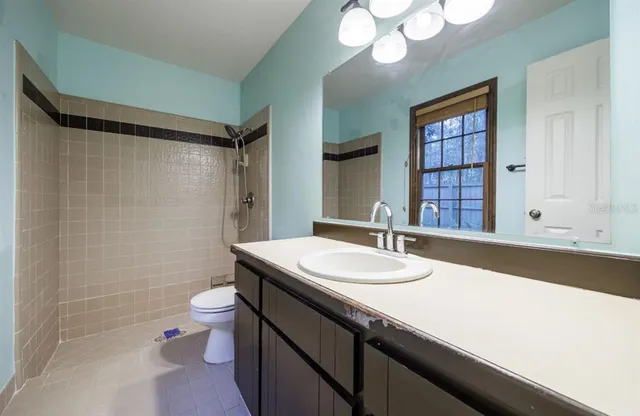 a bathroom with a granite countertop sink mirror vanity and toilet