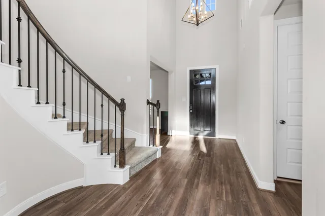 a view of a hallway with wooden floor and staircase