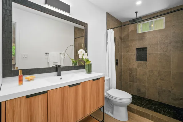 a bathroom with a sink a toilet and shower