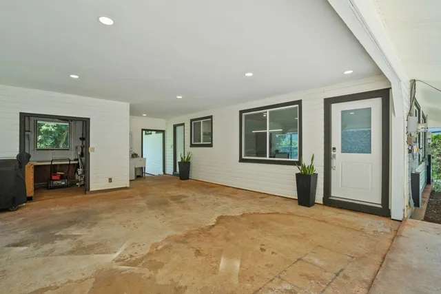 a view of an empty room with window and fire place