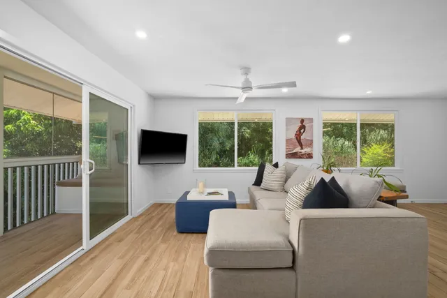 a living room with furniture tv and a large window