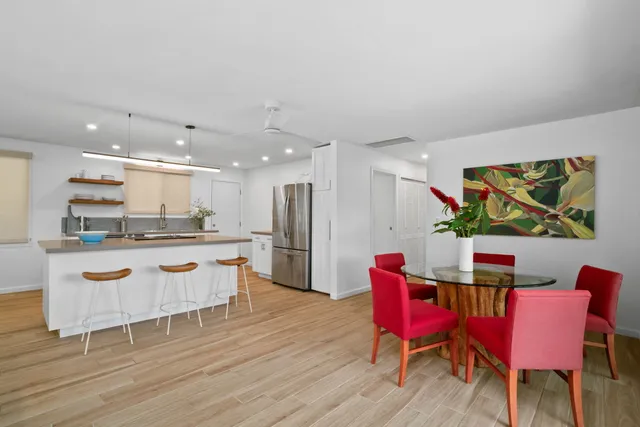 a kitchen with stainless steel appliances kitchen island granite countertop a dining table chairs and a stove