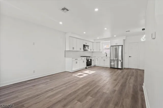a view of a kitchen with a sink and a refrigerator