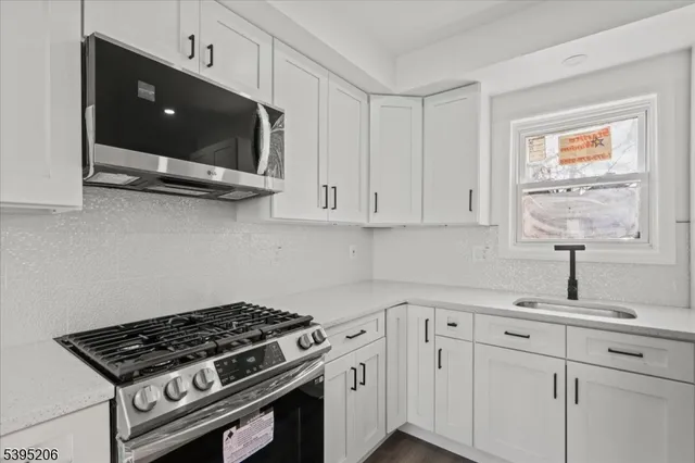 a kitchen with white cabinets and appliances