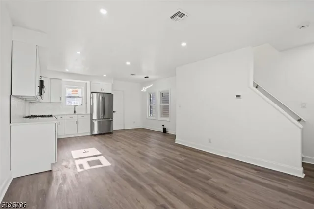 a kitchen with refrigerator and white cabinets