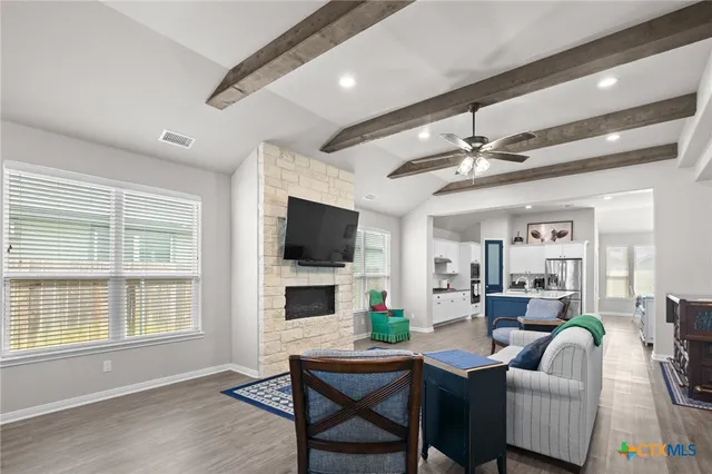 a living room with furniture a flat screen tv and a window