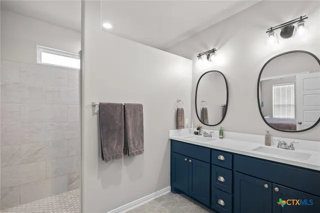 a bathroom with a double vanity sink and a mirror