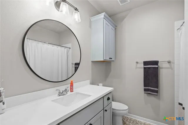 a bathroom with a sink a mirror a toilet and a sink