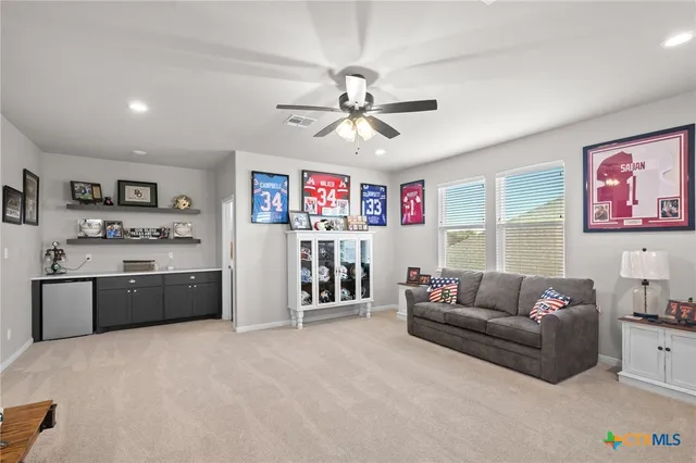 a living room with furniture and kitchen area