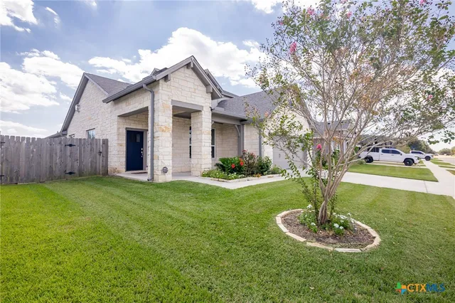 a front view of a house with a yard garage and outdoor seating