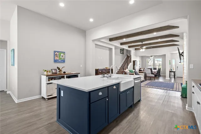 a large kitchen with a stove and wooden floor