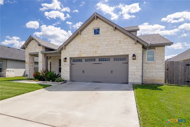 a view of a house with a yard and garage