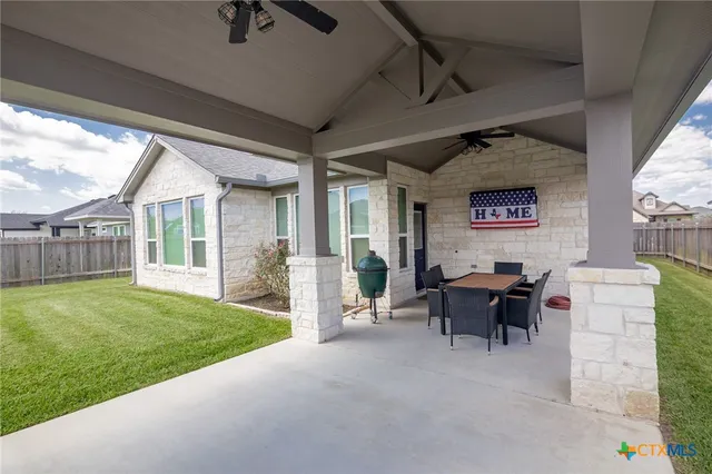 a view of a house with backyard porch and sitting area