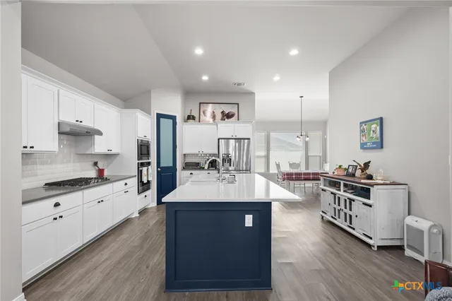 a large kitchen with stainless steel appliances a lot of counter space and a sink