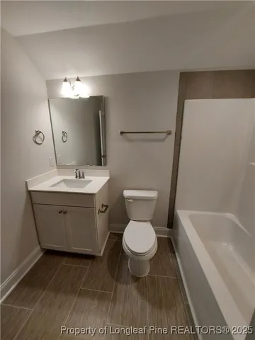a bathroom with a toilet sink a mirror and bathtub