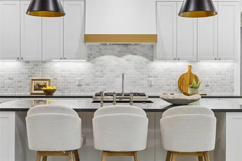 a kitchen with stainless steel appliances a stove a table and chairs