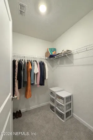 a view of walk in closet with clothes and shoes
