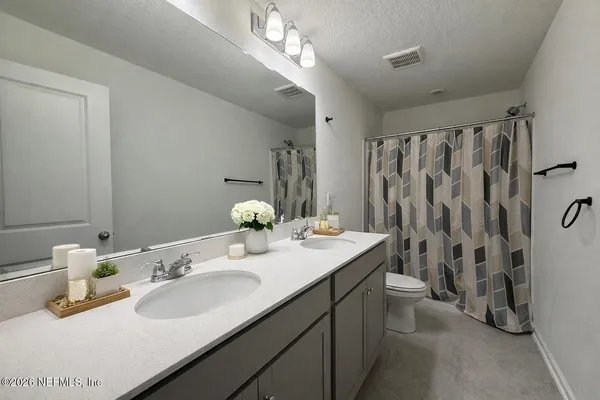 a bathroom with a granite countertop sink a toilet and a large mirror