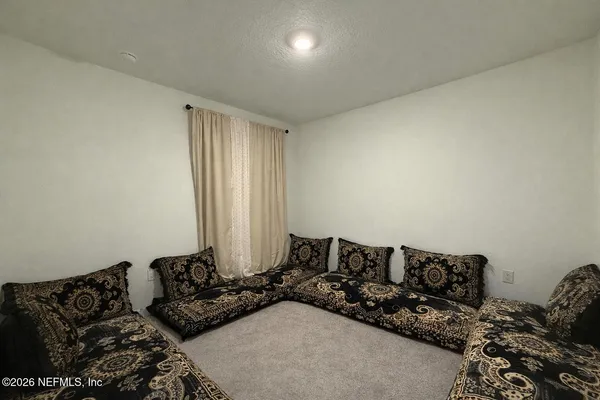 a bedroom with bed couch and window