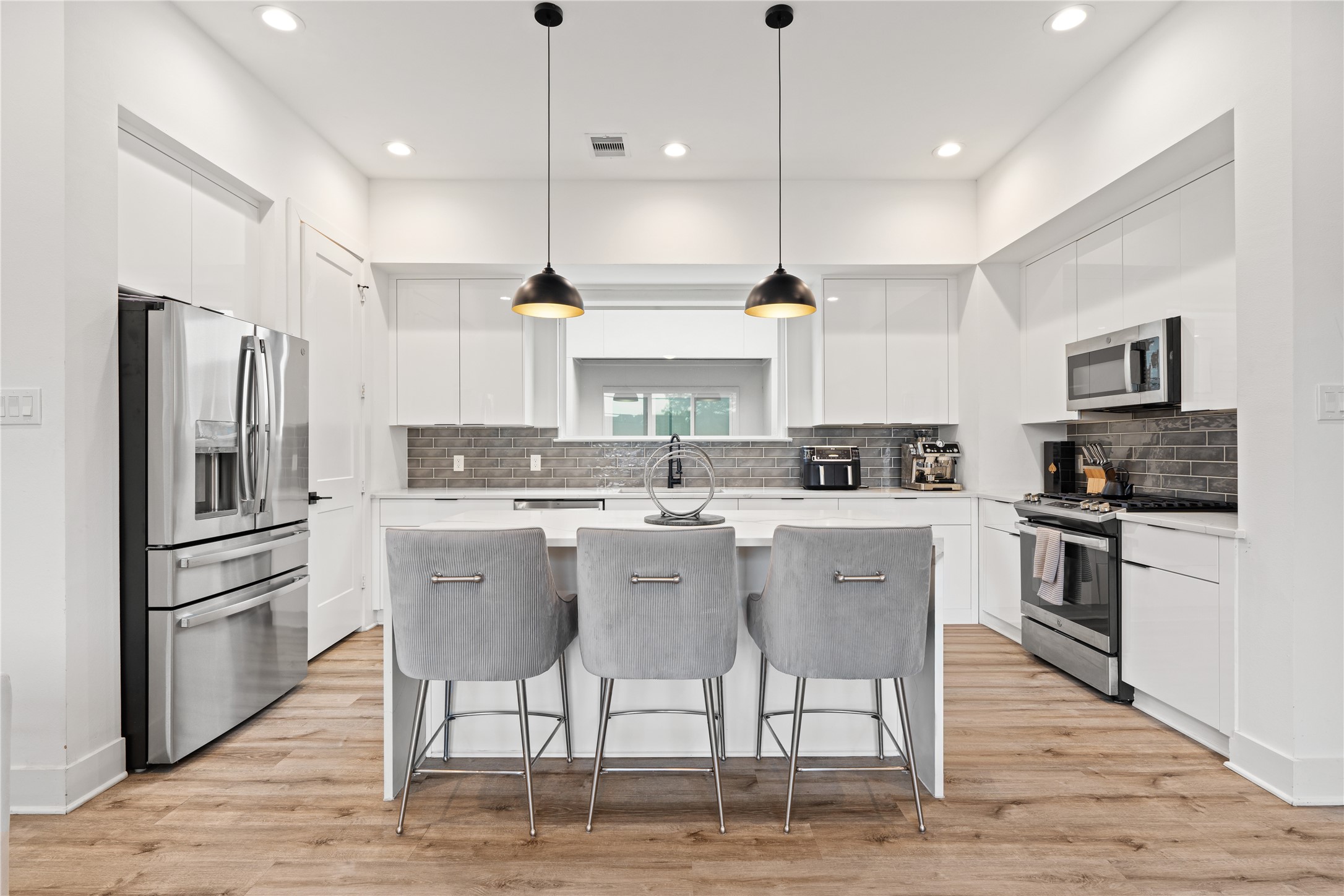 2404 Hadley Street, Unit C Houston, TX 77004 - Photo 5 of 16 a kitchen with stainless steel appliances granite countertop a sink a stove a refrigerator and island with wooden floor