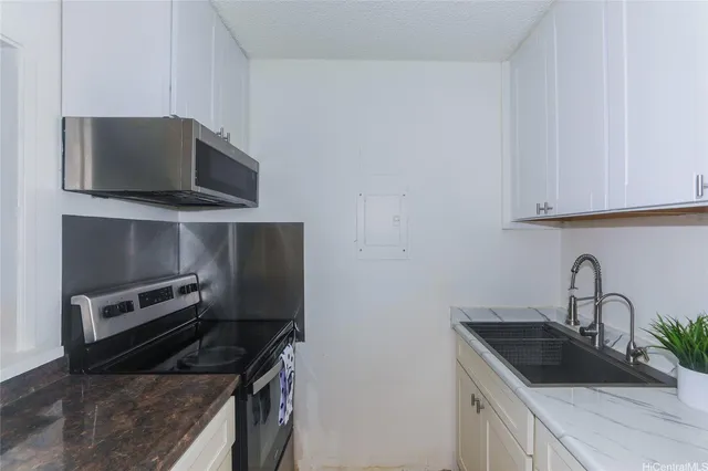 a kitchen with a sink and steel appliances
