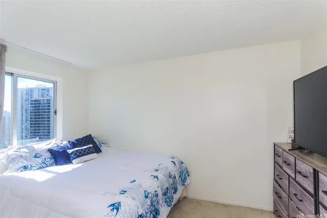 a bed sitting in a bedroom next to a window with tv