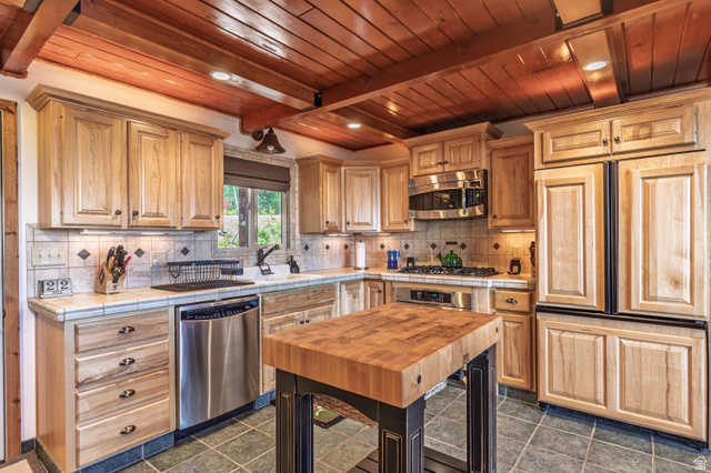 401 North Aoki Michi Road Brian Head, UT 84719 - Photo 11 of 58 Kitchen featuring wood-paneled ceilings, natural wood cabinetry, stainless steel appliances, tile backsplash, and a butcher block island