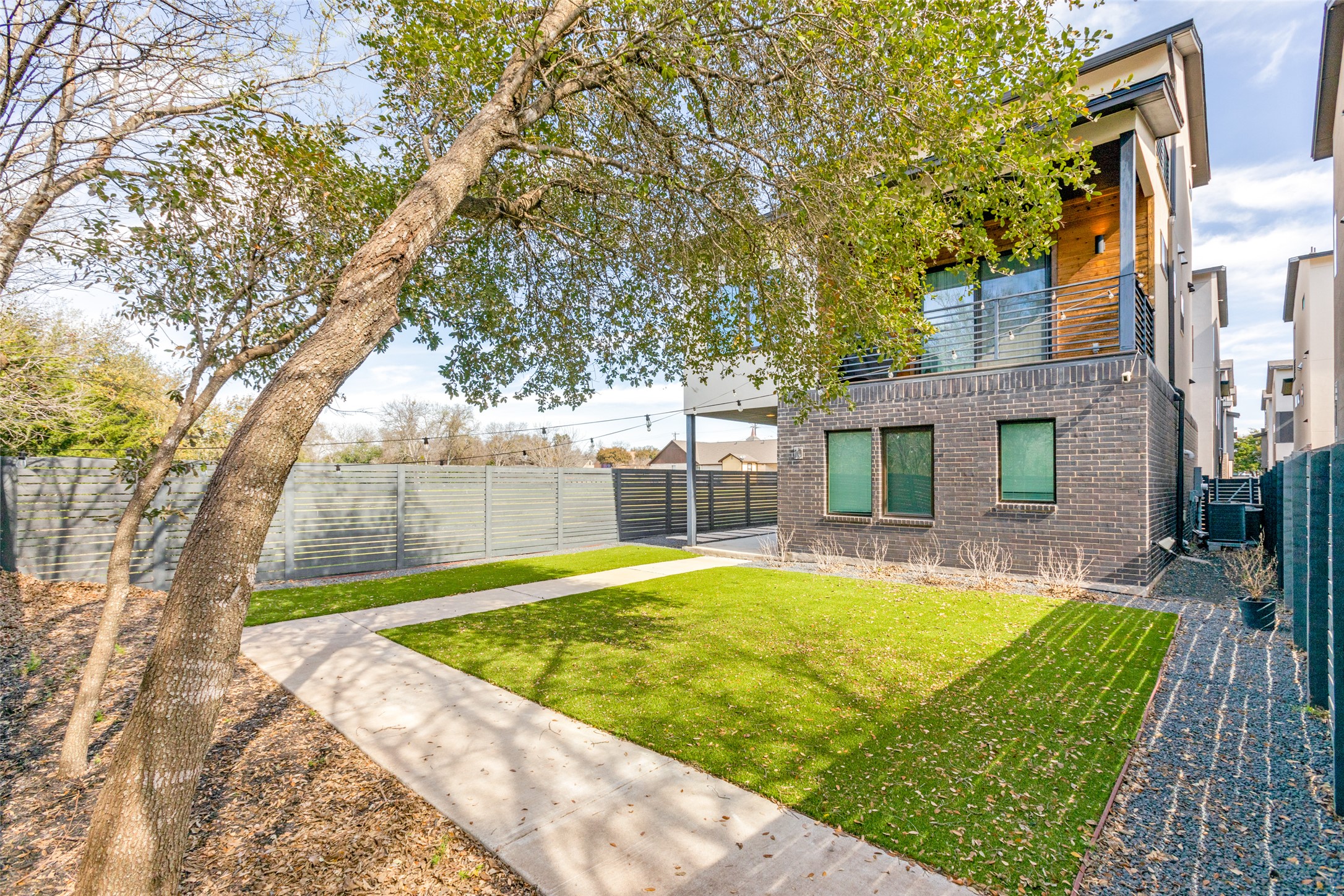 5002 Pecan Springs Road, Unit 10 Austin, TX 78723 - Photo 25 of 29 View of yard featuring central air condition unit, a balcony, and a fenced backyard