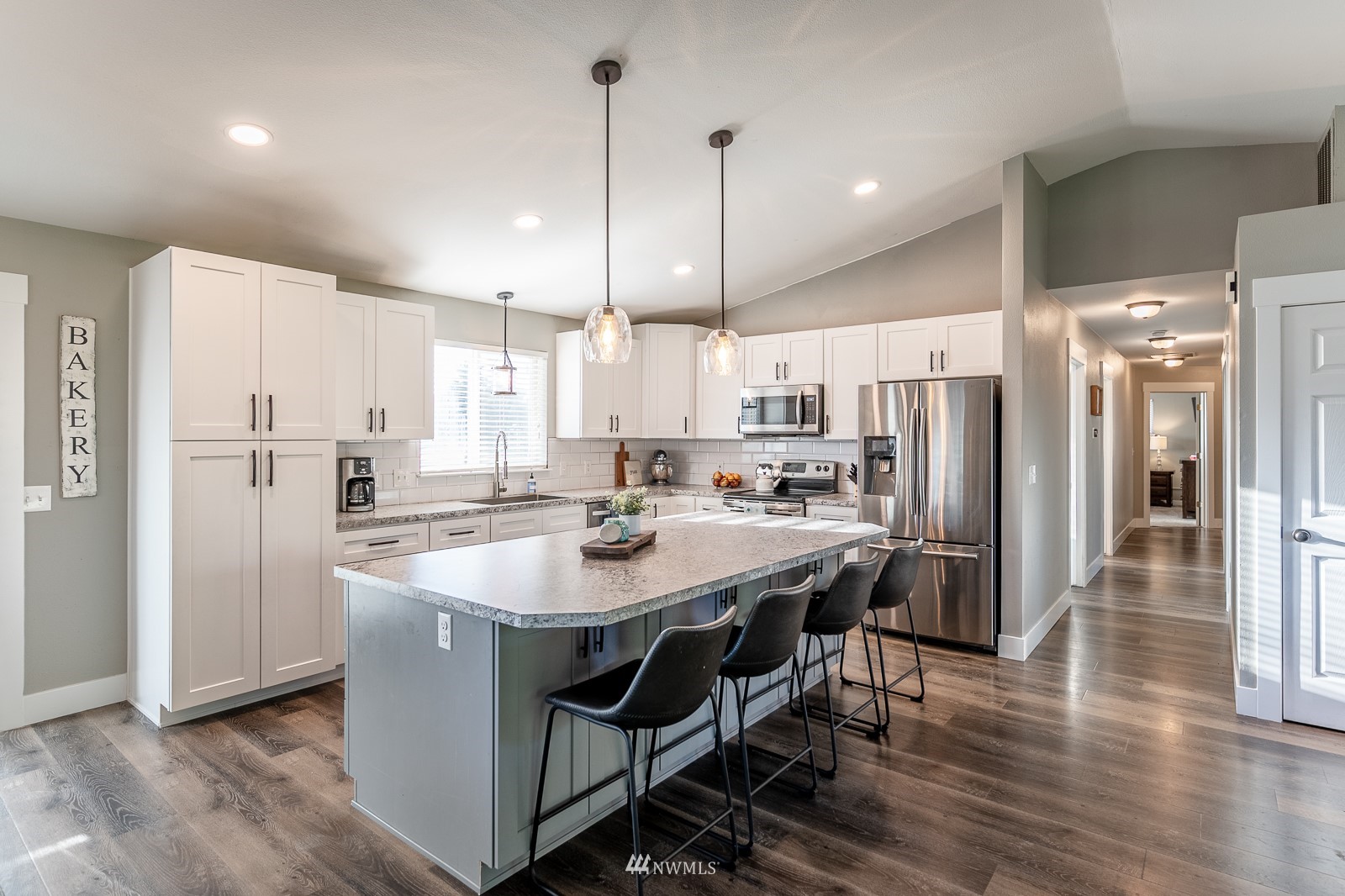 1027 South Sundance Road Othello, WA 99344 - Photo 24 of 40 a kitchen with stainless steel appliances kitchen island granite countertop a table chairs refrigerator and microwave