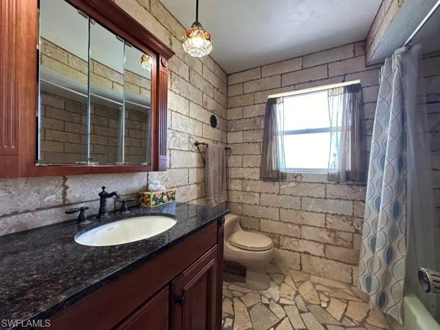 a bathroom with a sink a toilet a mirror and a shower