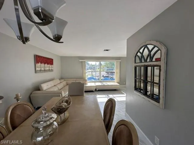 a living room with furniture two window and a wooden floor