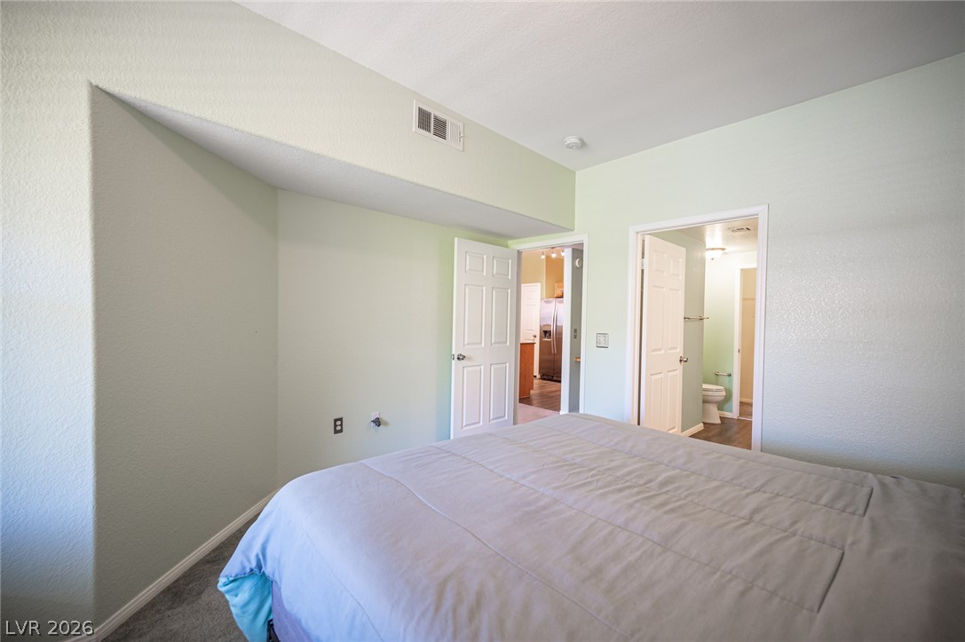 10550 West Alexander Road, Unit 2014 Las Vegas, NV 89129 - Photo 24 of 35 Well-lit sleeping quarters with a neutral color scheme and easy access to both kitchen and bathroom.