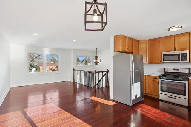 a view of a kitchen with fridge and wooden floor