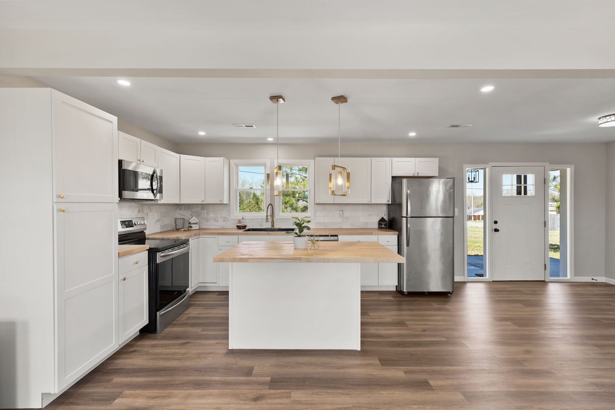 a kitchen with stainless steel appliances a refrigerator a stove top oven and white walls